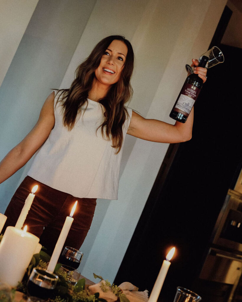 Camille Styles holding up a bottle of Rioja