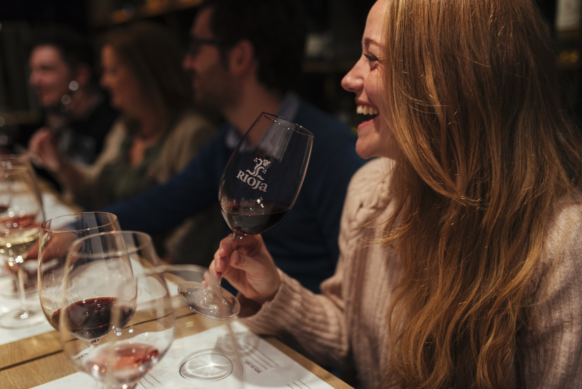 A woman smiles as she enjoys Rioja seasonal pairings