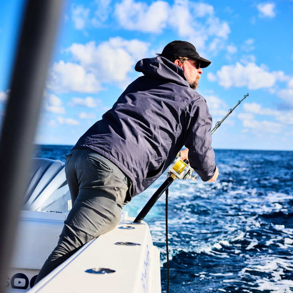 Man leans over fishing boat off the coast of Miami